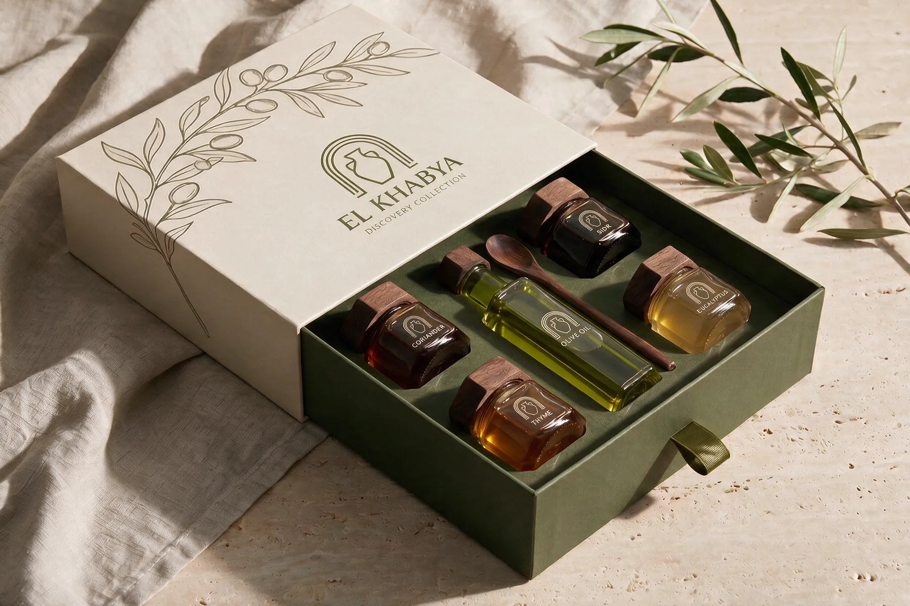 Discovery Collection — geöffnete El-Khabya-Box mit vier Honigen, Olivenöl und Holzlöffel auf einem Travertintisch