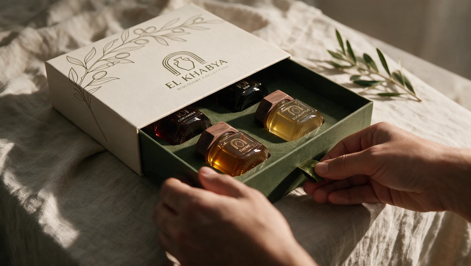 Hände öffnen eine El-Khabya-Geschenkbox auf einem Leinentisch, Honiggläser fangen das Licht