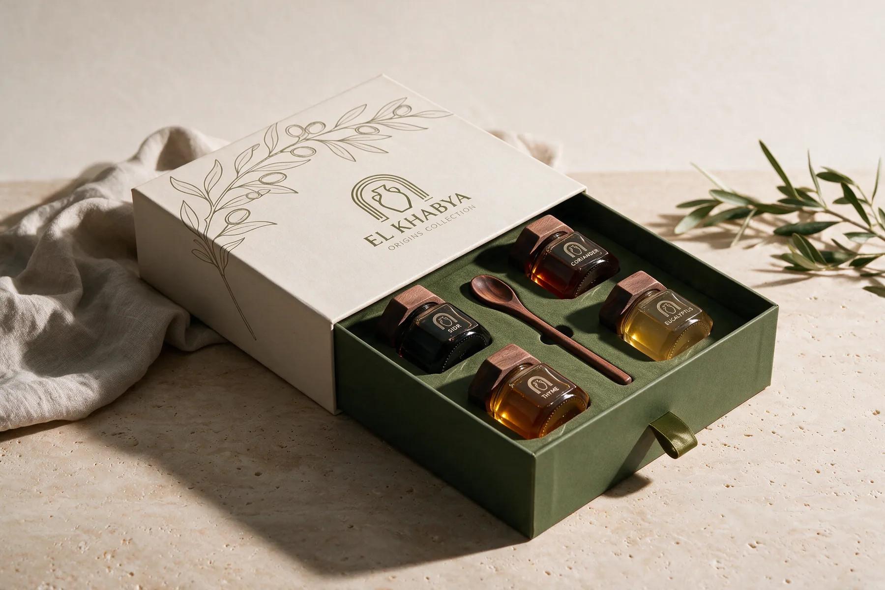 Origins Collection — geöffnete El-Khabya-Box mit vier Honigen und Holzlöffel auf einem Travertintisch